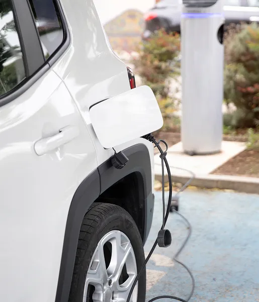 Voiture électrique en recharge sur borne de stationnement.