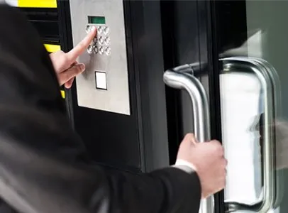 Technicien utilisant un badge pour ouvrir une porte sécurisée électrique.